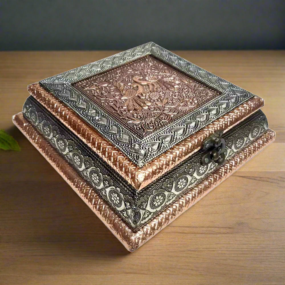 Front view of wooden dry fruit box with copper oxidized raised peacock design and four partitions
