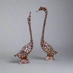 Decorative pair of metal swans polished in copper and silver, symbolizing love and beauty for home decor.

