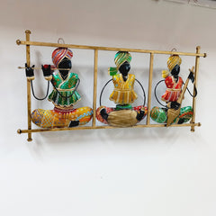Decorative Rajasthani magician metal wall hanging featuring three instrumentalists with vivid hand-painted artwork.