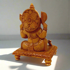 Decorative wooden Ganesh ji idol on carved chowki, made from kadam wood with detailed hand craftsmanship.