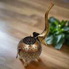 Elegant golden metal elephant candle holder featuring mesh design allowing light to shine through beautifully.