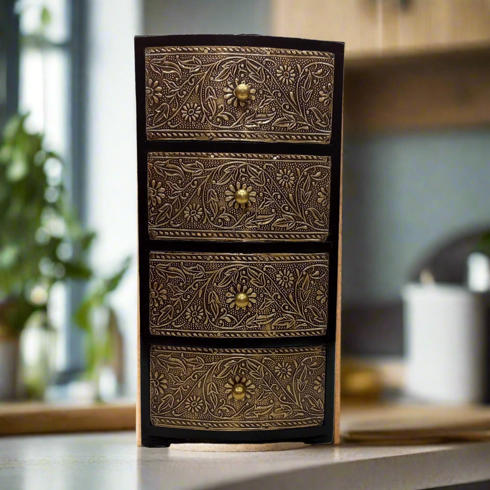 Wooden jewelry box with four drawers in antique finish and decorative metal sheet featuring flower and leaf patterns.
