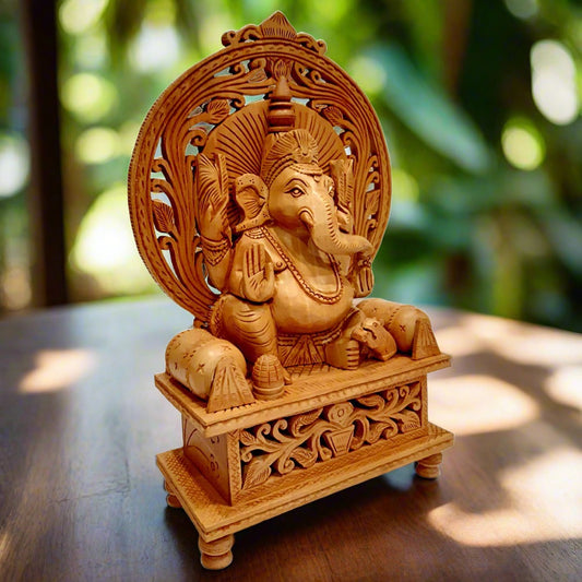  Handmade wooden Ganesh idol with detailed carvings, seated on a singhasan featuring undercut and leaf patterns.