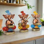 A beautiful set of three Ganesha statues playing musical instruments, a perfect addition to home decor.