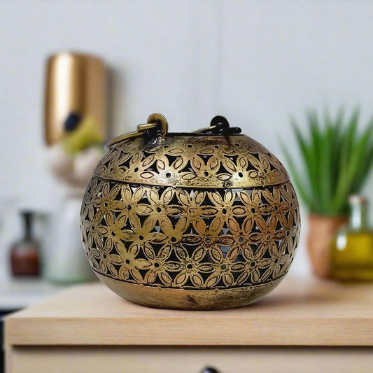 Golden oxidized metal candle holder featuring intricate meshwork and round shape, ideal for festive and home decor.