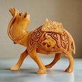 A magnificent hand-carved wooden camel idol featuring intricate deep carvings on the saddle and a unique regal posture.