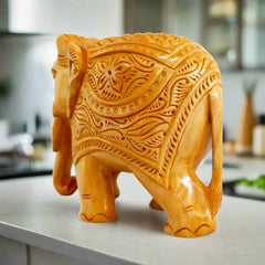 Hand-carved wooden elephant figurine with intricate detailing and fine craftsmanship.