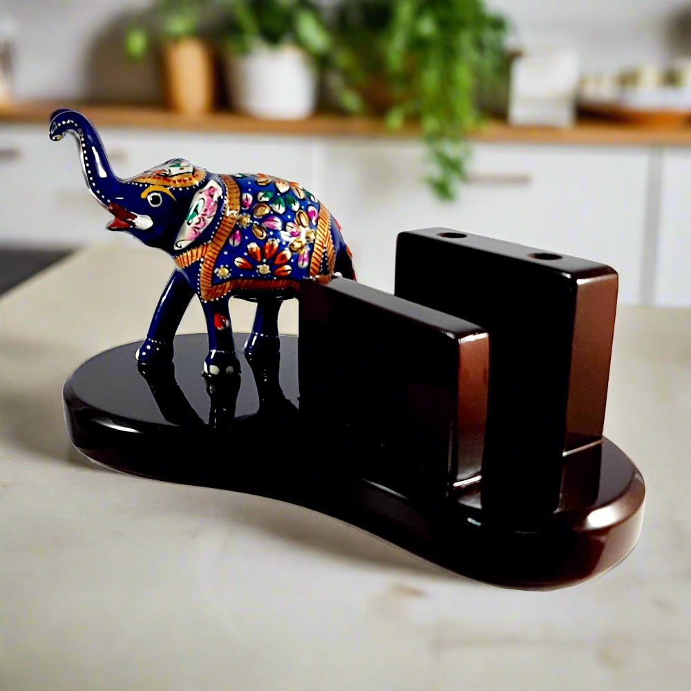 A hand-painted lucky elephant on a wooden pen stand, featuring detailed enamel and Meenakari work.
