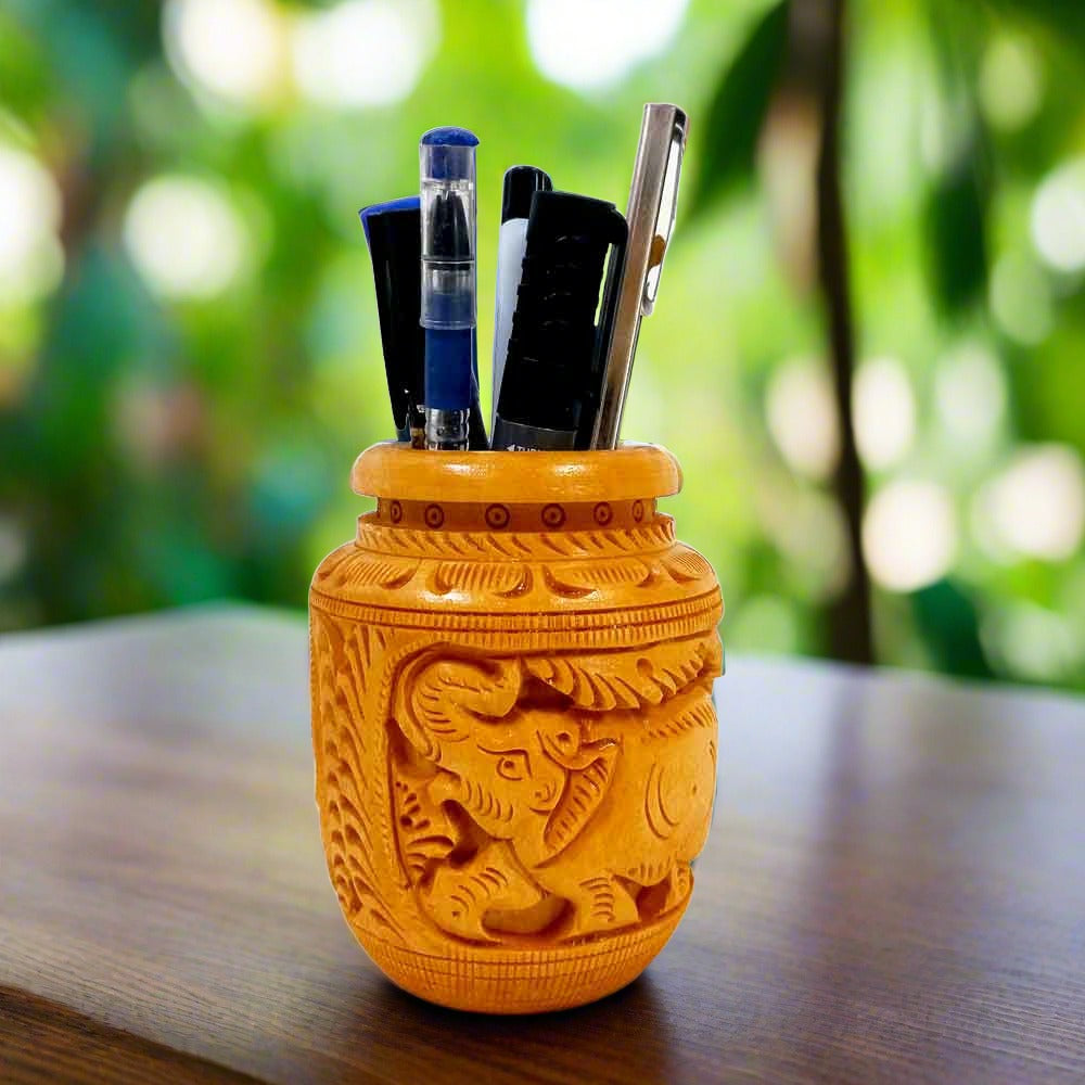 A handmade wooden pen holder with a beautiful pot-like shape and elephant carvings.

