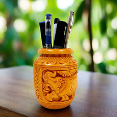 A handmade wooden pen holder with a beautiful pot-like shape and elephant carvings.

