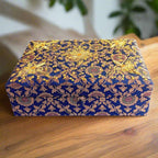 A handmade bridal makeup box made of silk fabric and decorated with zardosi work.