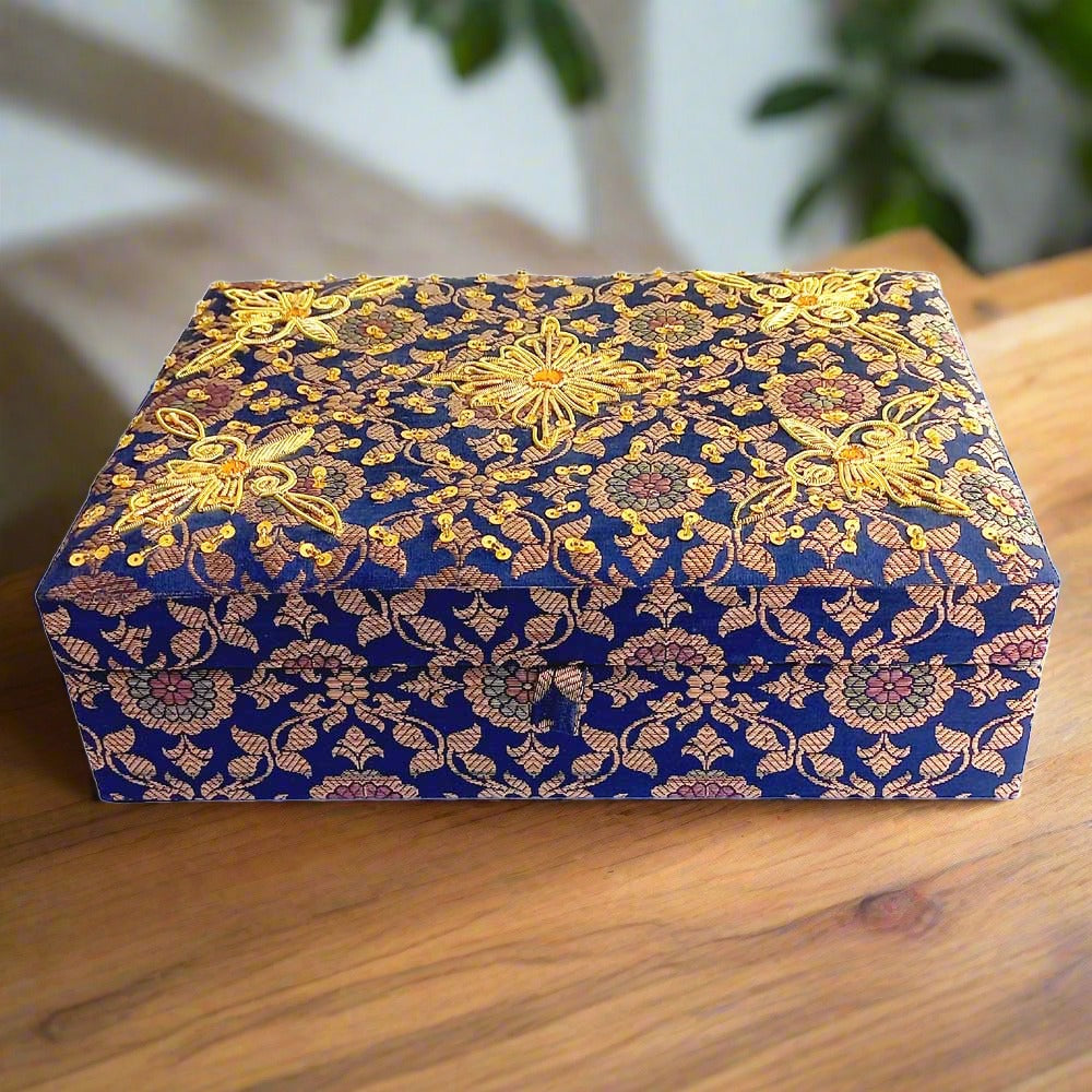 A handmade bridal makeup box made of silk fabric and decorated with zardosi work.