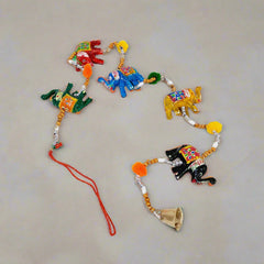 Paper mache elephant toran decorated with vibrant hand painting and traditional golden bell accents