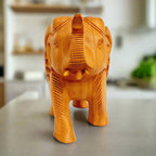 Side view of lucky trunk-up wooden elephant showpiece with intricate wood lattice patterns.