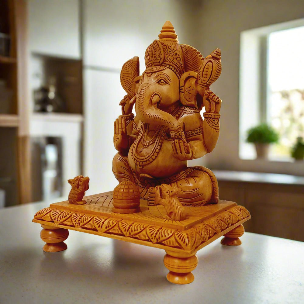 Kadam wood Ganesh ji idol sitting on intricately carved wooden chowki, decorated with hand workmanship and symbolic elements.