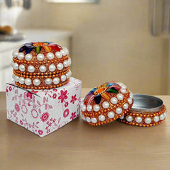 A round lac work kumkum box made of aluminum, decorated with pearls and stones, a perfect return gift.