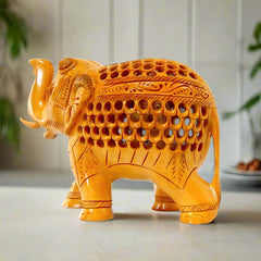 A beautiful carved wooden lucky elephant with its trunk up, featuring intricate carvings.