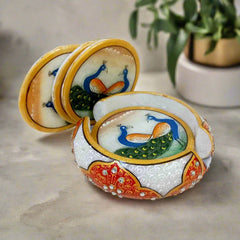 Set of six solid white marble round coasters hand-painted with peacock designs and emboss-painted marble holder.