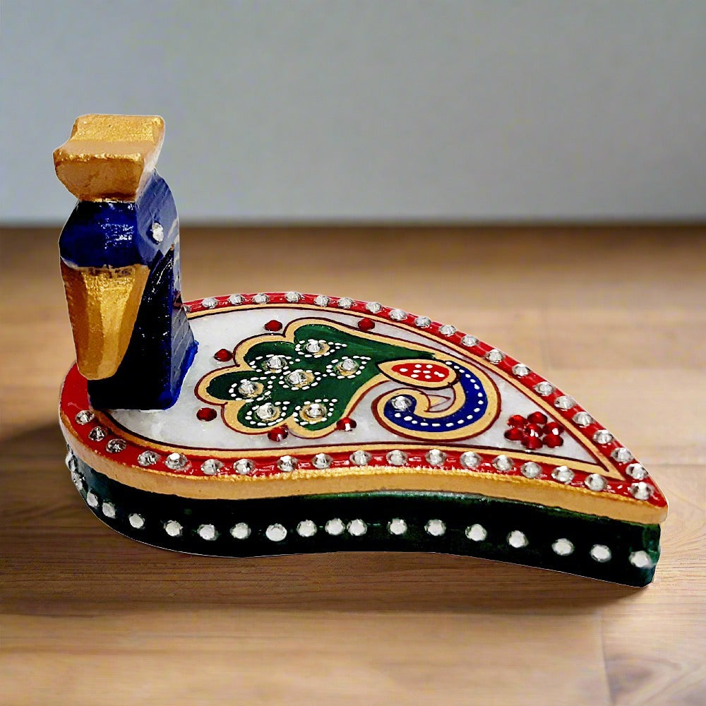A marble sindoor box with a beautiful peacock design, ideal for pooja room decor.