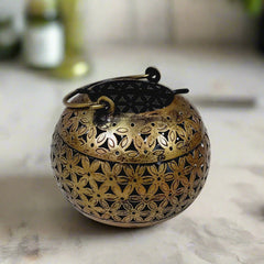 Metal candle stand with mesh design, polished in golden oxidized color, creating stunning light effects when candle is lit.