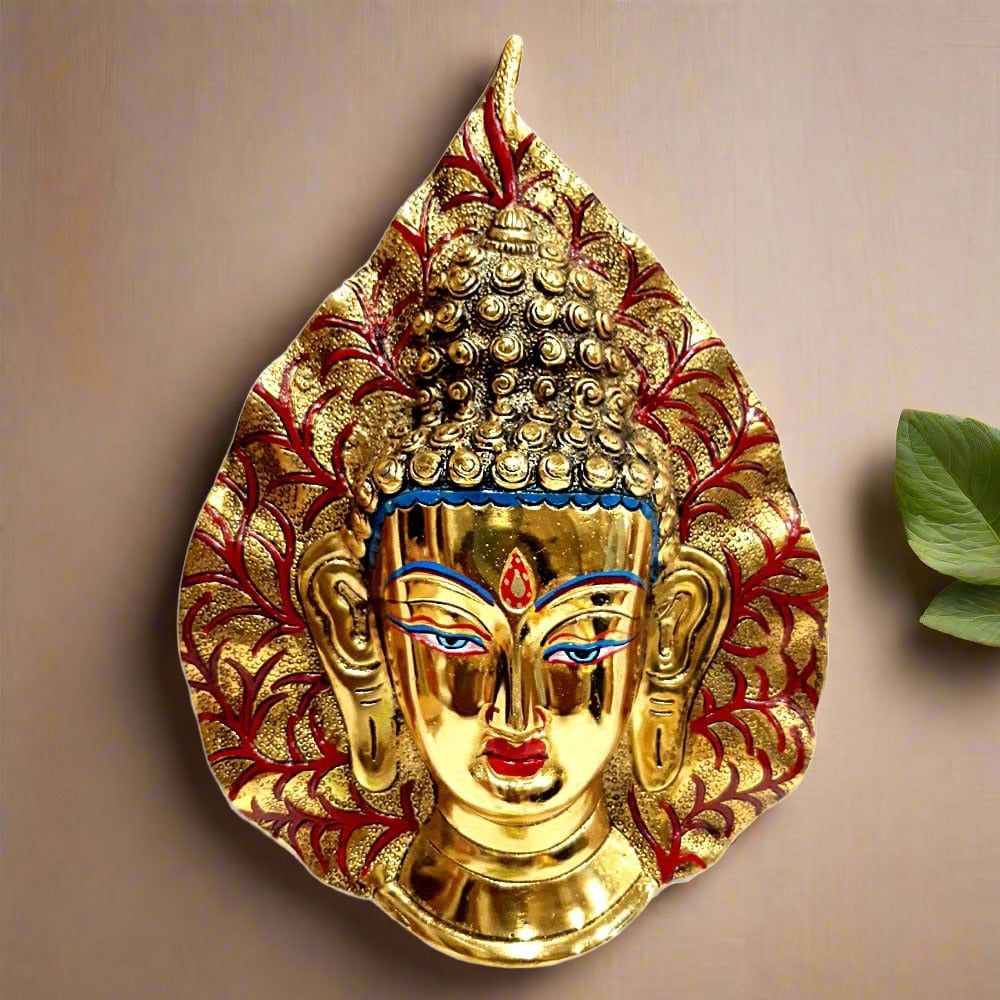 Metal Buddha wall decor polished with golden oxidize and hand painted, featuring Buddha’s face on top of a leaf.