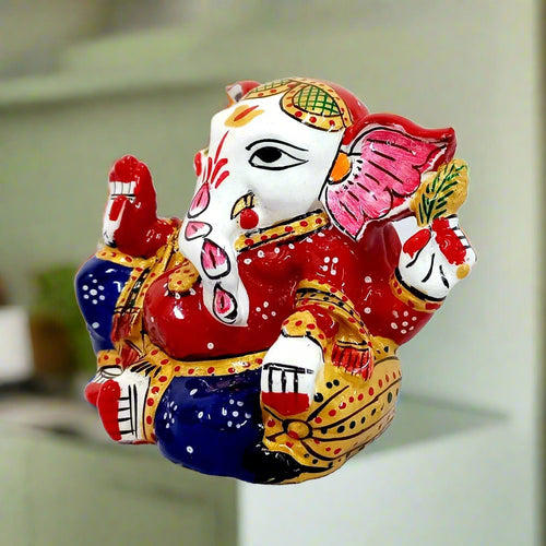 Metal Ganesha idol adorned with vibrant meenakari hand painting, ideal for car decoration