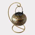 A golden metal mesh candle holder, a perfect centerpiece for a table.