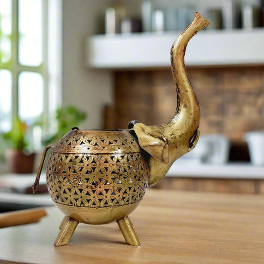 Modern metal elephant candle stand with golden mesh design, creating beautiful light patterns when a candle is lit.