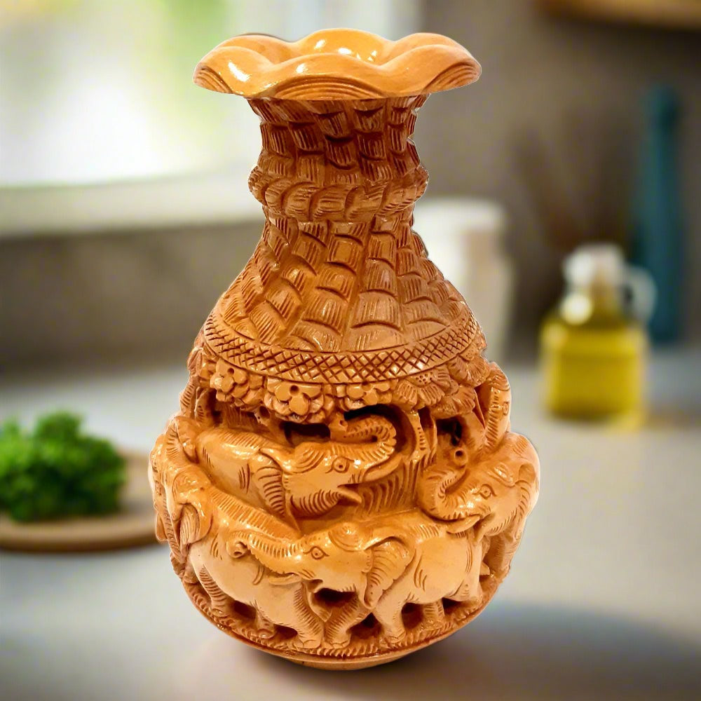 Closeup of amazing elephant family carvings on premium Kadamba wood vase.