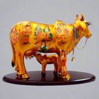 A resin Kamdhenu cow idol with hand-painted images of various gods and goddesses.