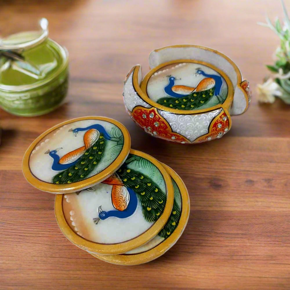 Round solid marble coasters hand-painted with peacock motifs, including a stylish embossed coaster holder.