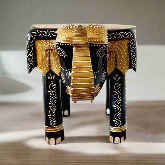 A wooden elephant in a saluting stance, designed as both a stool and a showpiece stand.