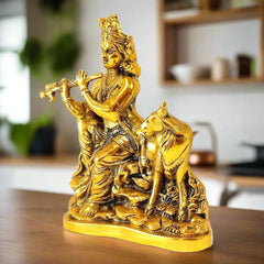 A beautiful sitting Murali Krishna showpiece with a cow's calf, made of metal.