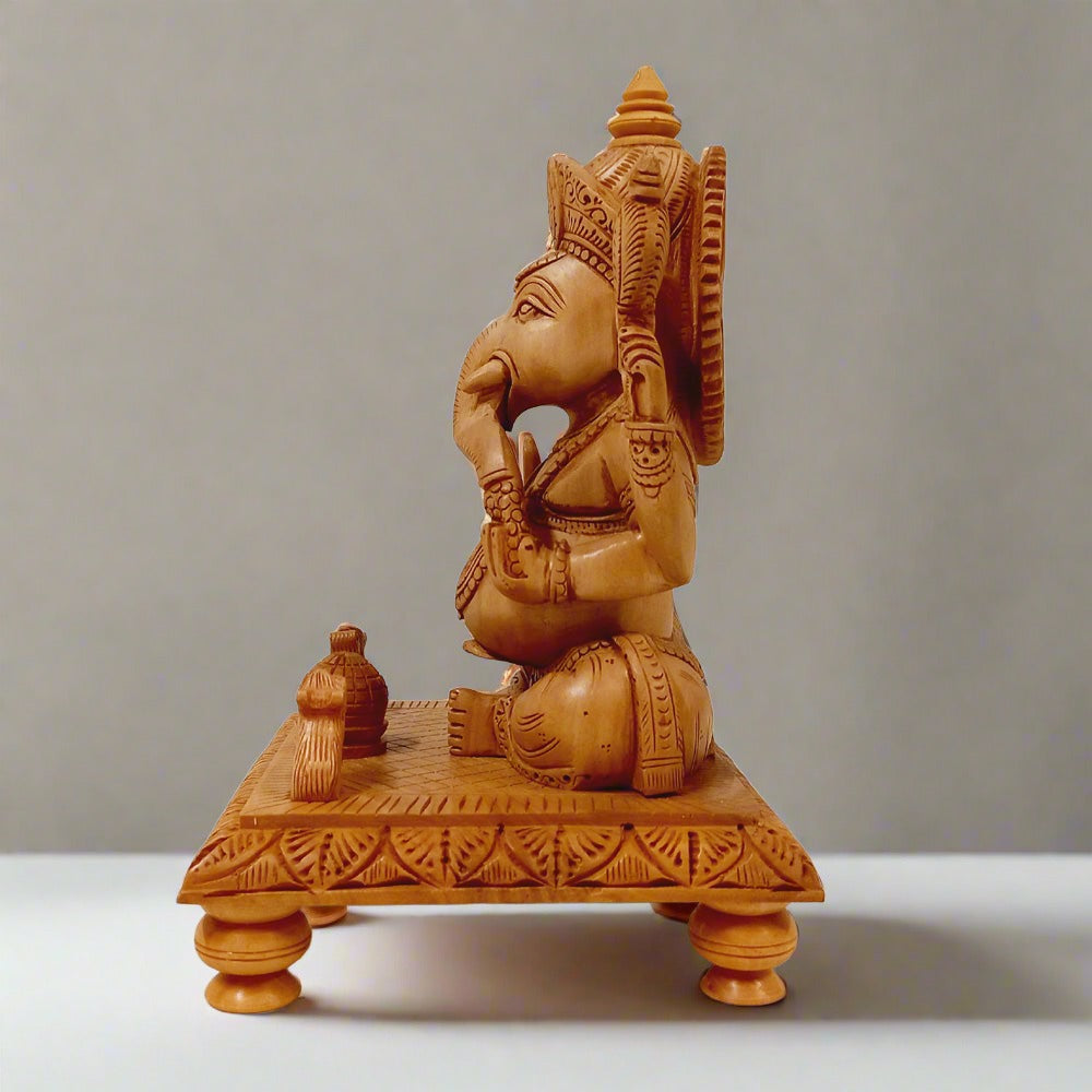 Spiritual wooden Ganesh idol sitting on wooden chowki with hand-carved details, perfect for prayer rooms.