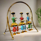  A stunning home decor doll set with three dolls sitting on a metal swing that actually moves.