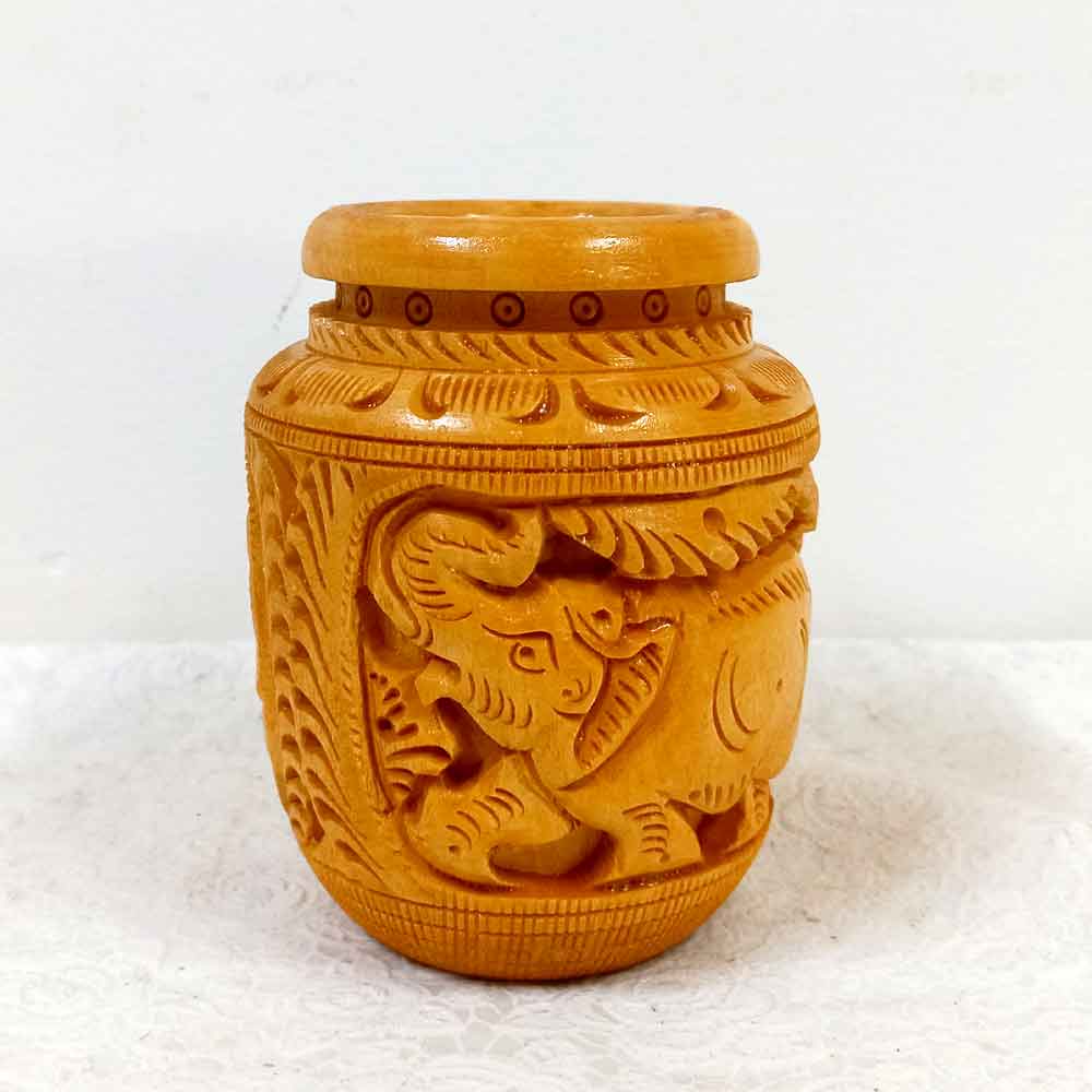 A thick wooden desk organizer with elephant carvings, designed to hold a lot of pens and pencils.