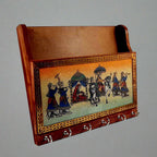 Side view of wooden wall key holder showing hooks and top paper compartment.
