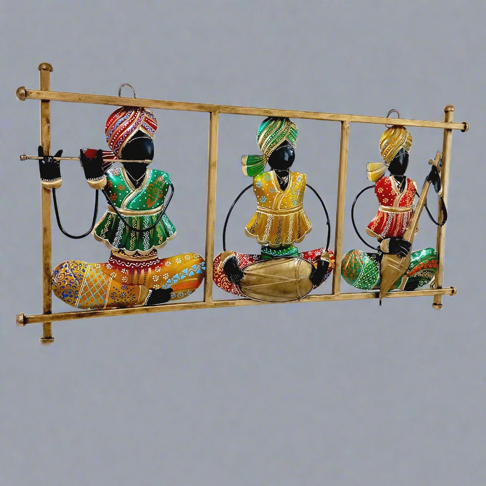 Traditional Rajasthani metal wall art showing magician musicians playing instruments, decorated with vibrant hand painting.