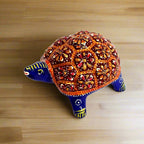 Side view of large Meenakari painted metal tortoise for home pooja.