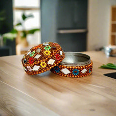 A beautiful kumkum box with vibrant lac art work, a very good gift to give as a return gift to women.