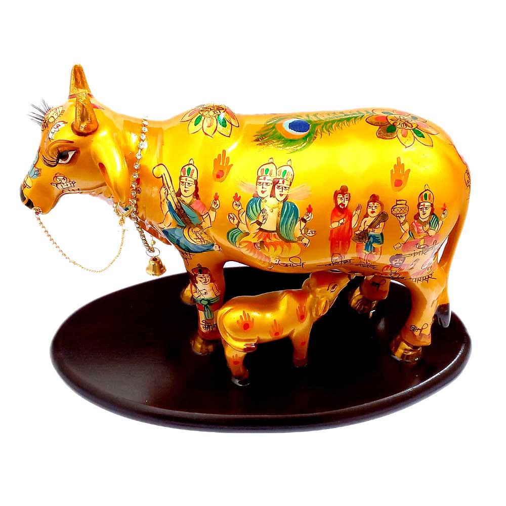A beautiful, worshipped Kamdhenu cow with calf figurine, decorated with a bell and diamond chain.